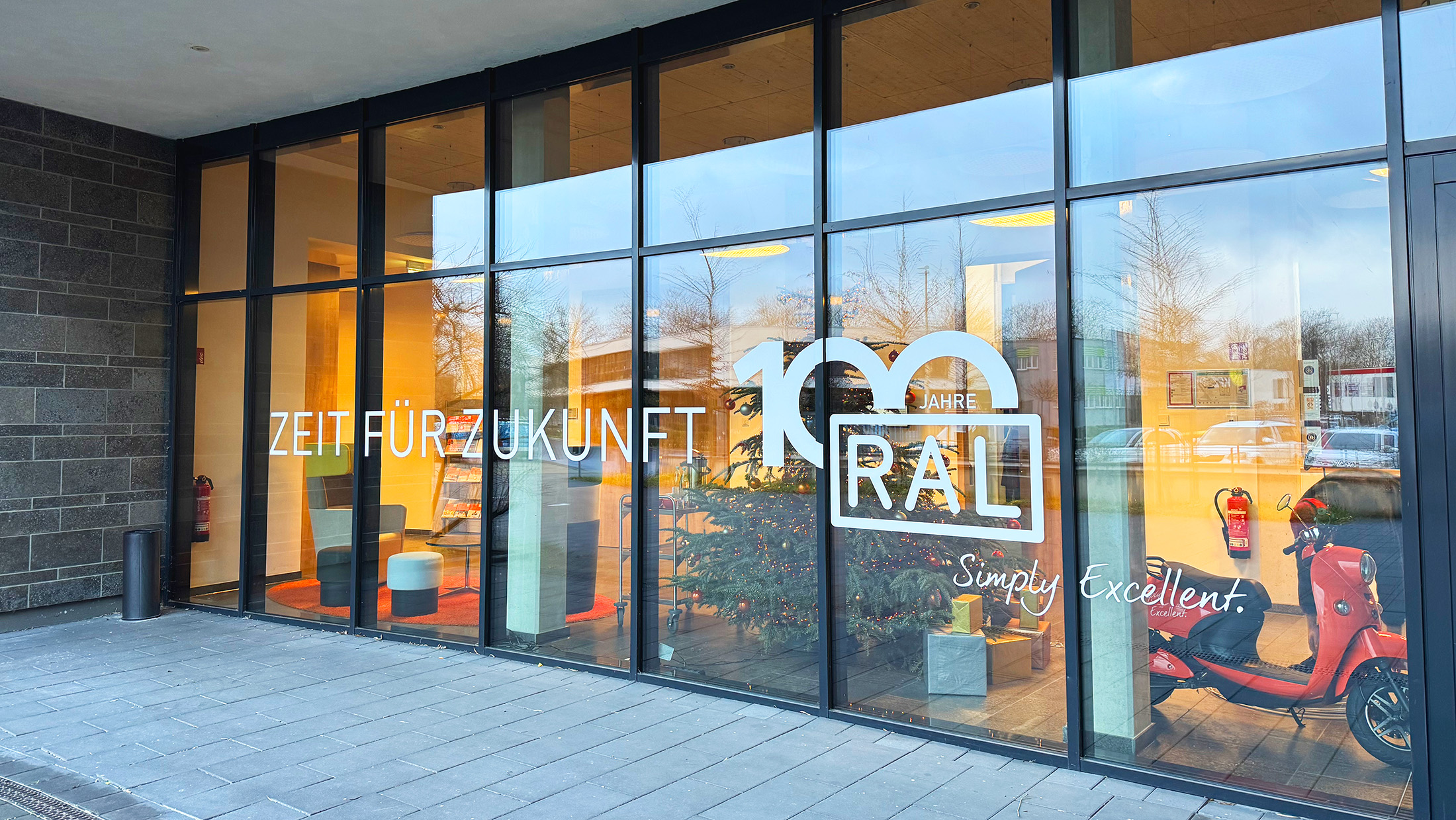 Fensterfolierung mit Folienplot – RAL-Jubiläum im Corporate Design, umgesetzt durch die KBZ Werbetechnik in Köln Nippes